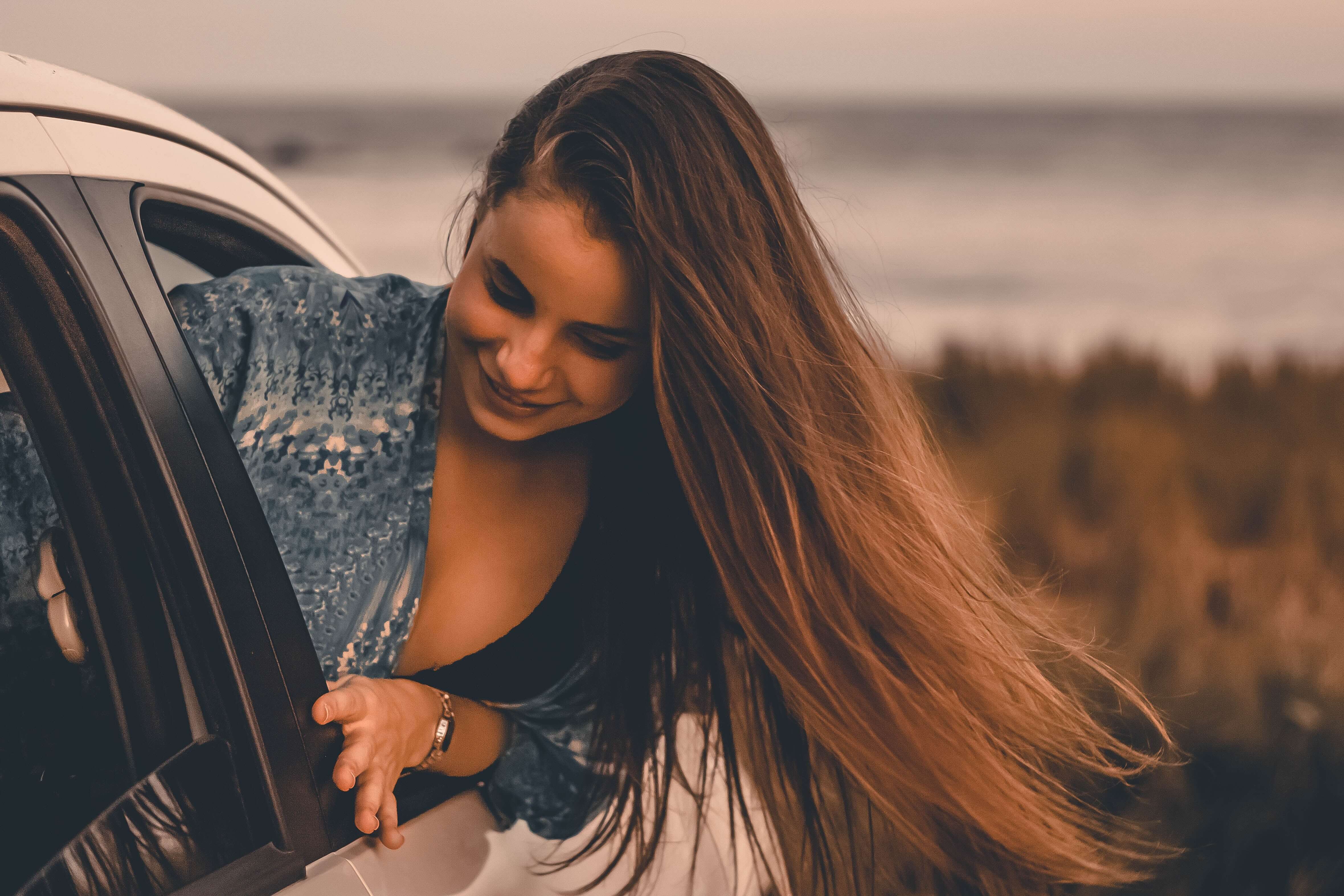 mujer asomando por la ventanilla de un coche